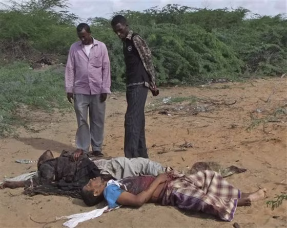Local men&nbsp;view the body of Fazul Abdullah Mohammed, front right, and another unidentified man in Mogadishu, Somalia, after last week's shooting.
